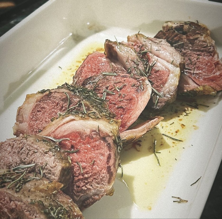 leg of lamb sliced with rosemary on top